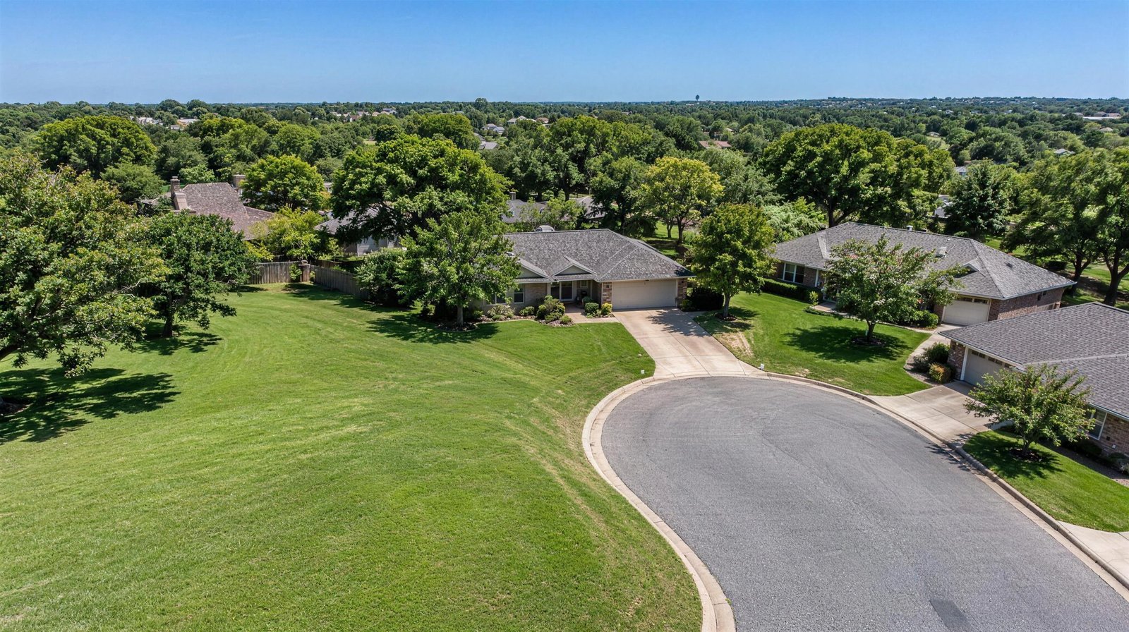 Aerial view of a quiet cul-de-sac with ranch homes and mature trees in Bedford, Texas at midday