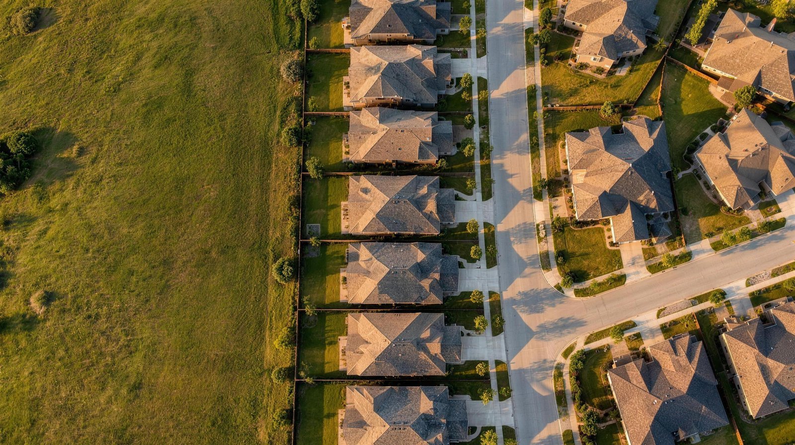 Aerial view looking straight down at new subdivision rooftops in Mansfield, Texas at golden hour